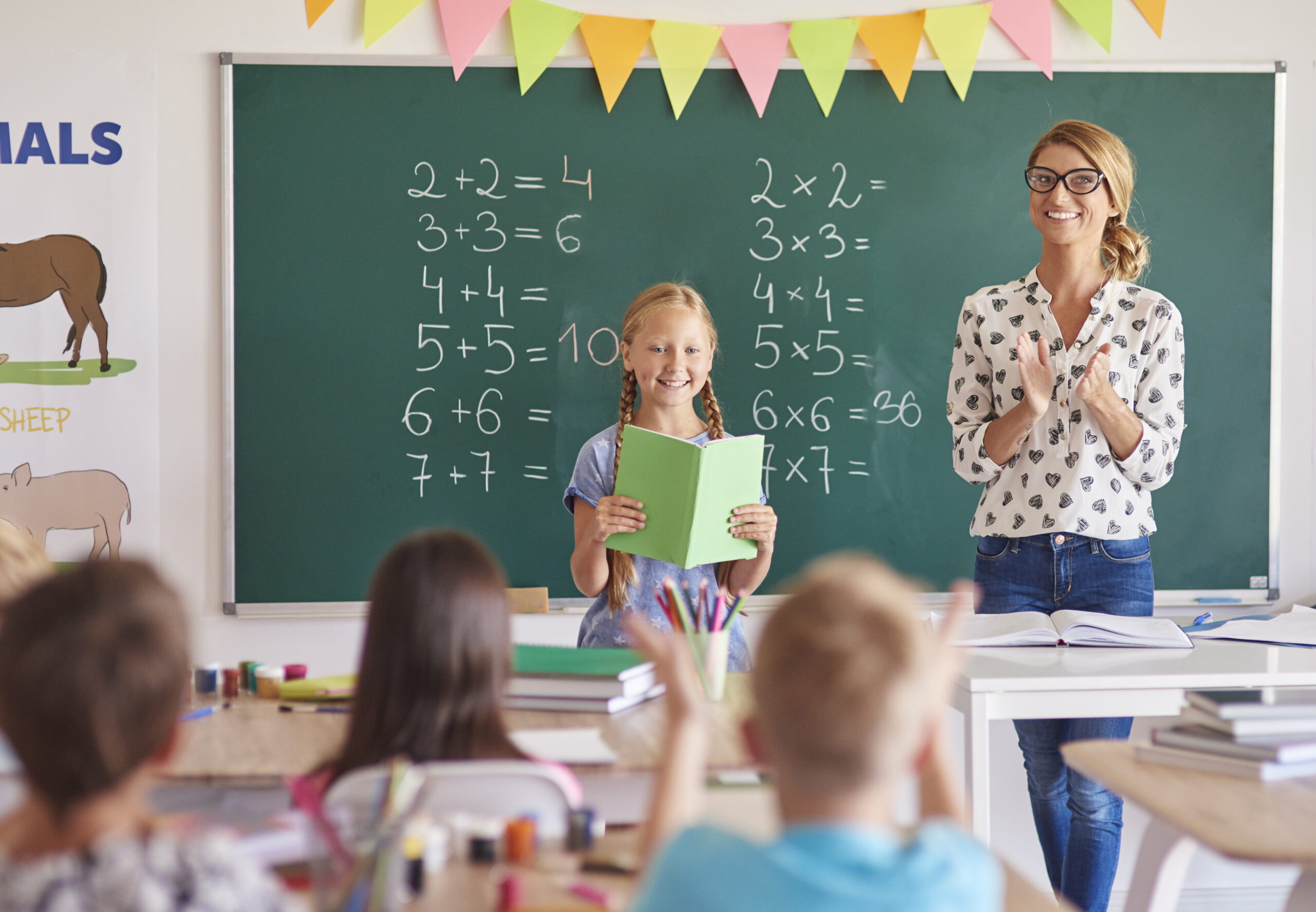 Teacher explaining multiplication tables to beginners using fun methods in a classroom setting